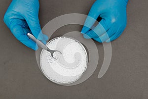 Plastic granules . Polypropylene, polyethylene pellets in hands with gloves. Quality control of plastic in the laboratory in