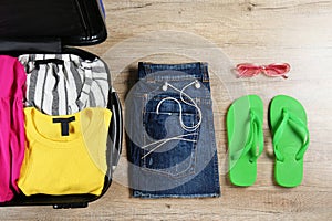 Plastic hardshell suitcase packed with casual clothing items