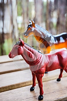 Plastic horse toys on a wooden surface