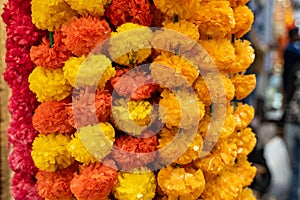 Plastic lei pompoms in yellow and orange for sale at a market in Old Delhi India