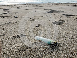 Plastic lighter trash on sandy sea ecosystem,microplastics industrial pollution
