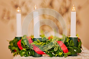 Plastic lingonberry crown with red satin ribbon and white electric lights. Saint Lucias traditional candlelight crown in closeup