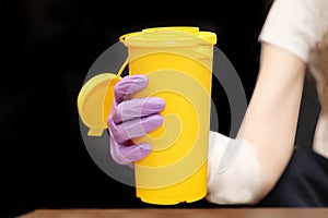 Plastic medical waste container in hand