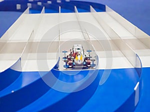 Plastic Model Scale Miniature racing Car running on lane track.