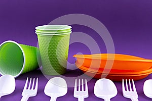 Plastic orange green waste collection on purple background. Concept of plastic pollution and ecology problem