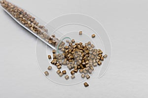 Plastic pallets . Plastic raw materials in granules for industry.Polymeric dye gold on a silver background. Plastic granules after