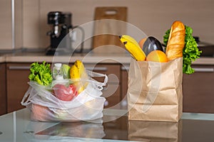 Plastic and paper bags with food on the kitchen table. Choosing the use of environmental packaging and plastic rejection