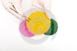 Plastic pellets . Colorant for polymers in granules. Plastic pellets in the hands with gloves and tweezers