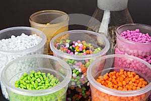 Plastic pellets. Dyes for plastic, polypropylene, polyethylene. Plastic granules in a measuring container and test tubes in the