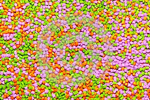 Plastic pellets. Orange green and pink Polypropylene granules sc photo