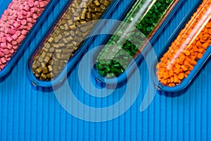 Plastic pellets .Polymeric dye in test tubes on corrugated background.Chemical background with plastic pellets photo