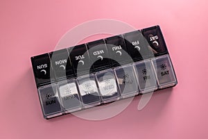 Plastic pillbox on pink background
