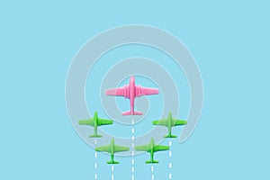 Plastic pink and green toy aeroplanes on a light blue background photo