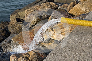 Plastic pipe throwing water into the sea, pollution concept