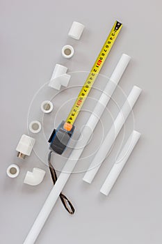 Plastic pipes for the water system, ruler and measuring level on grey background. Repair service, sale, online. Flat lay. Copy