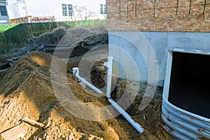 Plastic piping and a rainpipe against and around the a drainpipe in ground house