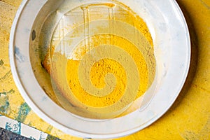 Plastic plate with yellow pigment powder for artist`s work