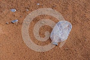 Plastic pollution in the desert sand. Need for awareness of environmental protection, recycling, and protecting the world.