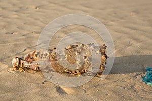 Plastic products clog nature more and more. Plastic bottle covered in sea barnacles and sponges foulers and cast ashore on the