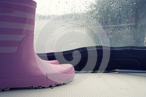 Plastic rain boots pink color on white floor