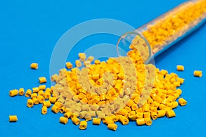 Plastic raw materials in granules for industry.Yellow Polymer on a blue background. Plastic granules