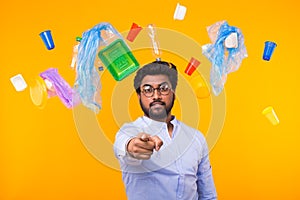Plastic recycling problem, ecology and environmental disaster concept - Indian man point on you on yellow background