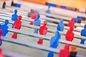 Plastic red and blue football players on table.