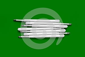 Plastic refills for ballpoint pens. Refills for a ballpoint pen. White ink refills on a green