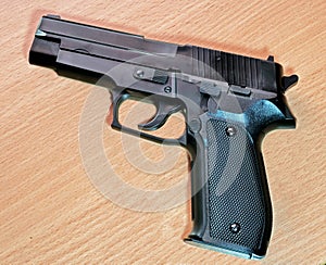 Plastic replica of a handgun on a wooden surface