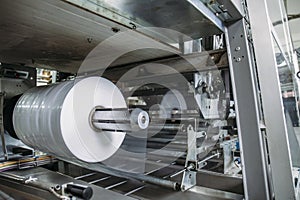 Plastic roll in industrial food packaging machine equipment tool at factory workshop