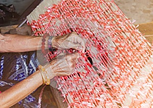 Plastic rope tied on thread by old women hands, old folk way silk thread fasten step