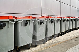 Plastic rubbish bins against gray wall