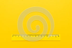 Yellow plastic ruler on the yellow background