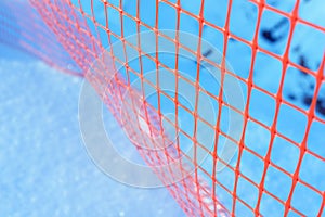 Plastic safety net for construction site. Construction mesh on winter snow