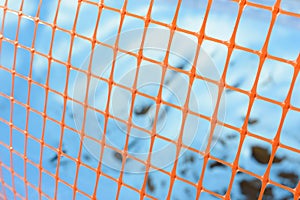 Plastic safety net for construction site. Construction mesh on winter snow