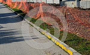 A plastic safety net is intended to prevent people from entering the construction site. it is a cheap design that is rather symbol