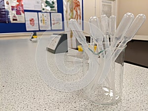 Plastic science pipettes stored in a glass beaker photo