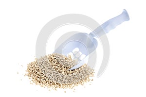 Plastic scoop for cleaning cat litter and a pile of filler on a white background