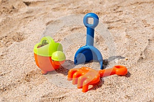 Plastic scoop, rake and watering can for playing on the beach