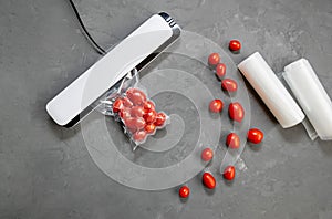 Plastic sealing machine. Vacuum packaging of fresh tomatoes. Flat lay