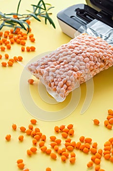 Plastic sealing machine. Vacuum packing of fresh sea buckthorn berries. Long-term storage of products