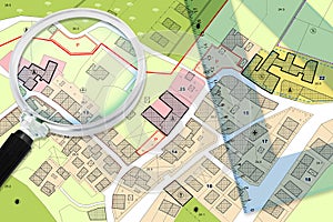 Plastic set square and magnifying glass over an imaginary General Urban Plan