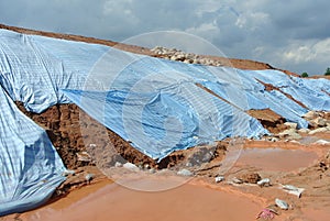 The plastic sheet is spread over the surface of the slope to prevent erosion. photo