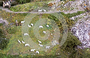 Plastic shepherd guards his sheep at the scenic model landscape