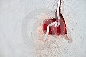 Plastic socket box and electrical wires on plastered wall