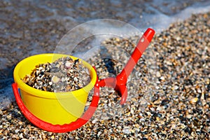 Plastic spade and bucket in sand