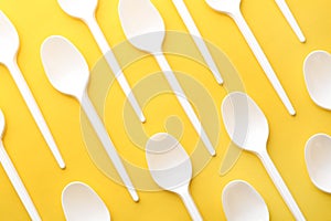 Plastic spoons on color background, top view. Picnic table