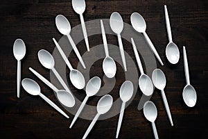 Plastic spoons scattered on wooden table
