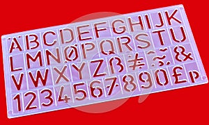 Plastic stencil alphabet tool.