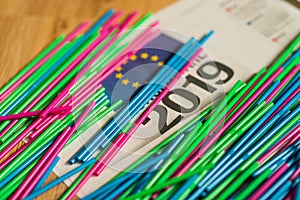 plastic straws on news paper sheet with 2019 and EU sign on it. ban act of plastic packaging in Europe 2019